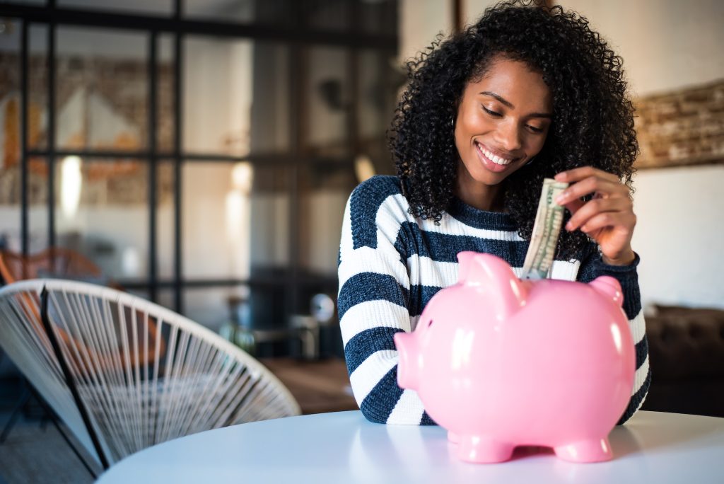 Black woman with saving piggy bank