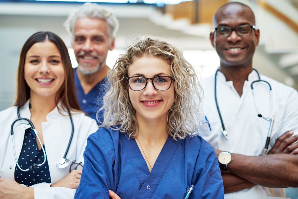 Cheerful medics looking at camera in clinic